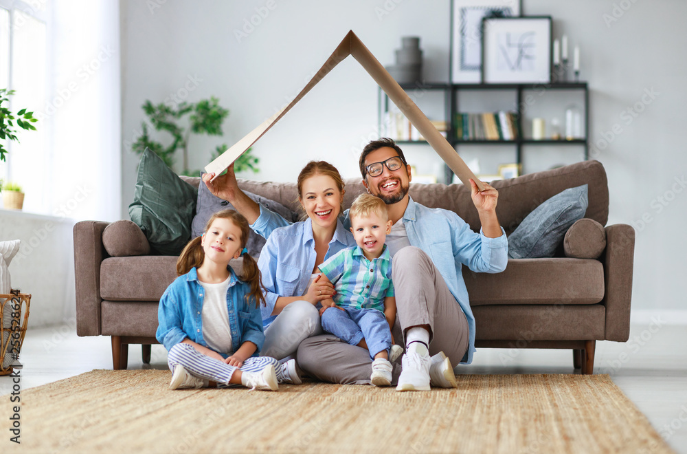 concept of housing and relocation. happy family mother father and kids with roof at home .